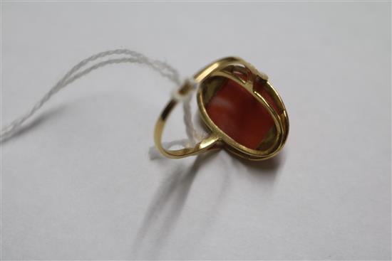 A yellow metal and oval cabochon coral ring, size R.